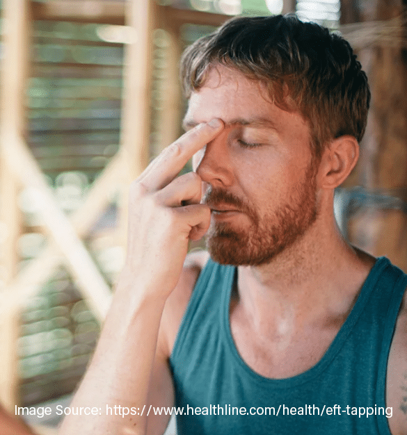 man tapping space between eyes with eyes closed