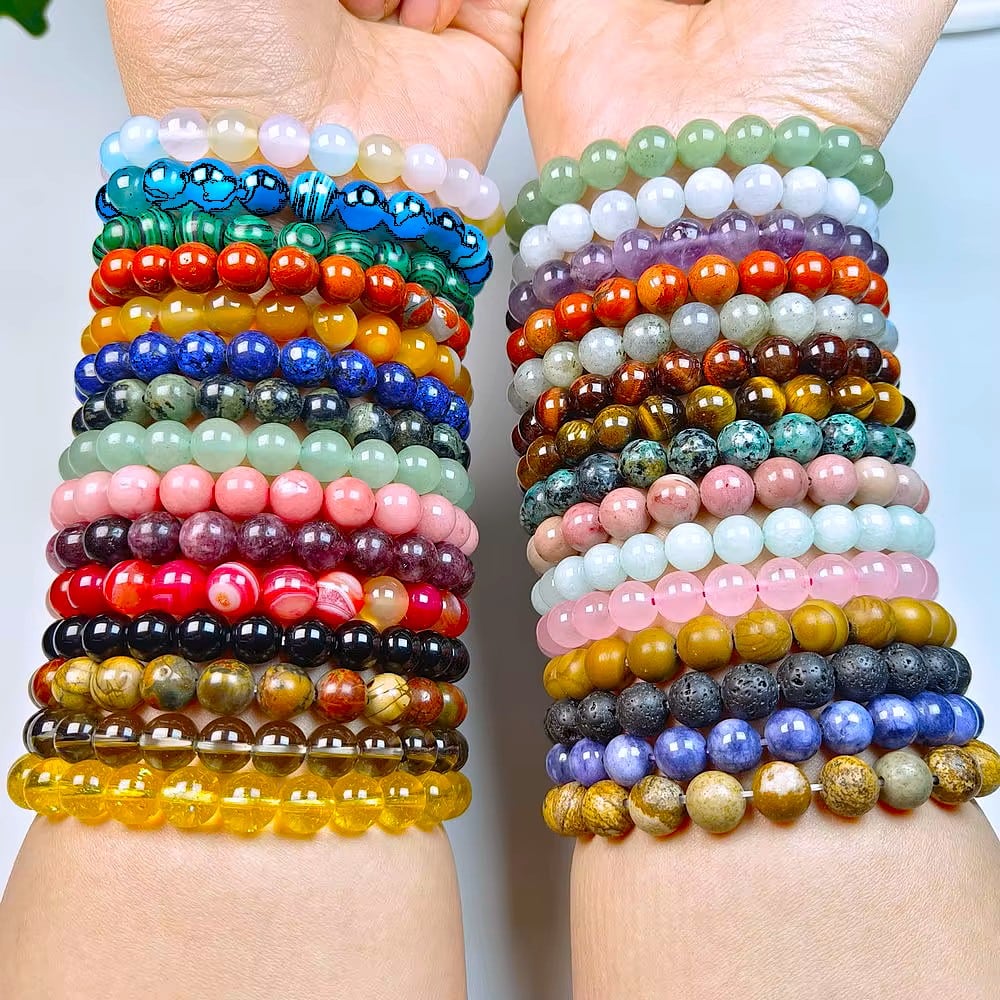 two wrists facing up, showing multiple colorful beaded bracelets